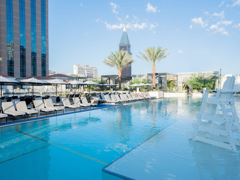 a pool with chairs and umbrellas in a hotel