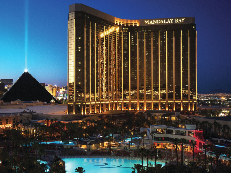 a large building with lights on it with Mandalay Bay in the background