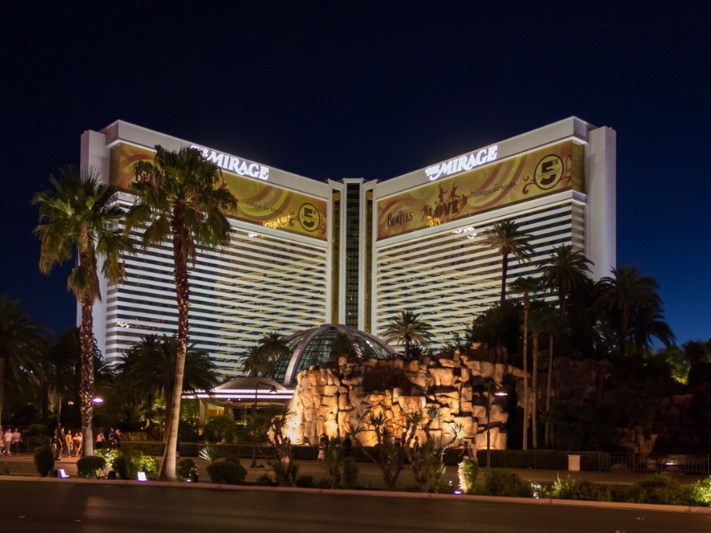 a large hotel with palm trees with The Mirage in the background