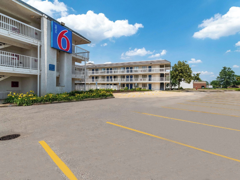 a parking lot with a building and a sign