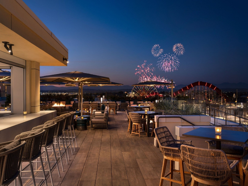 a rooftop bar with fireworks in the sky