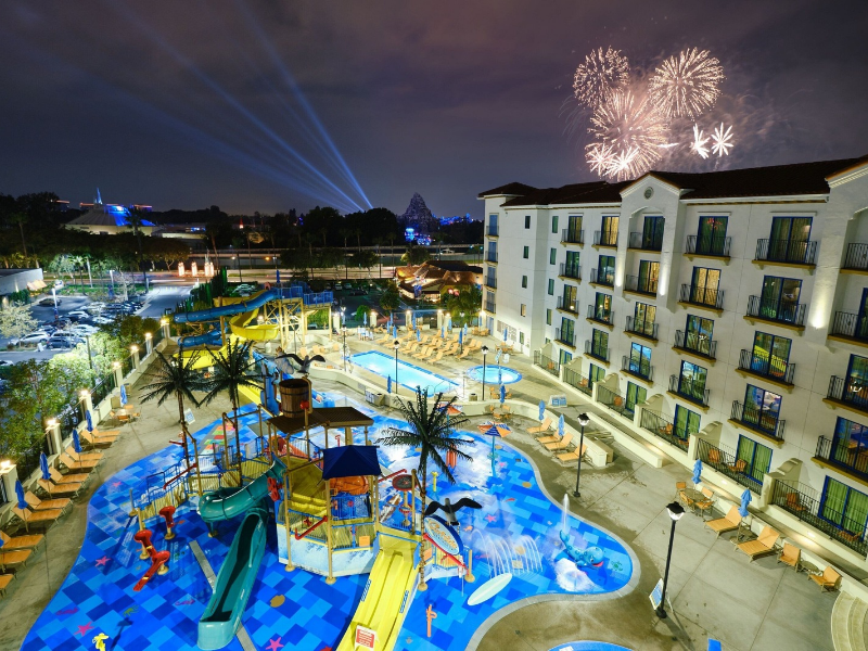 a pool and building with fireworks in the background