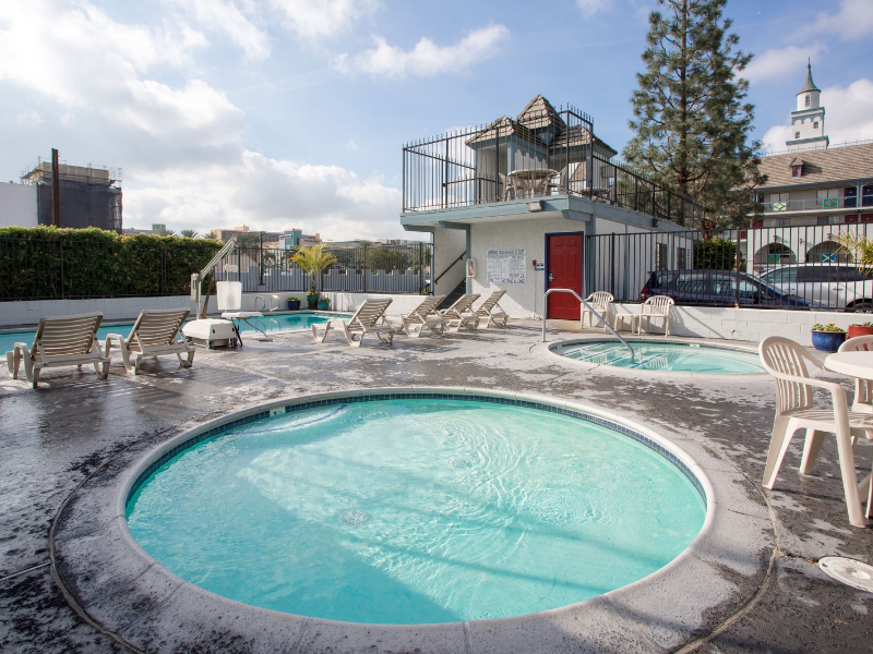 a pool with a hot tub and chairs around it